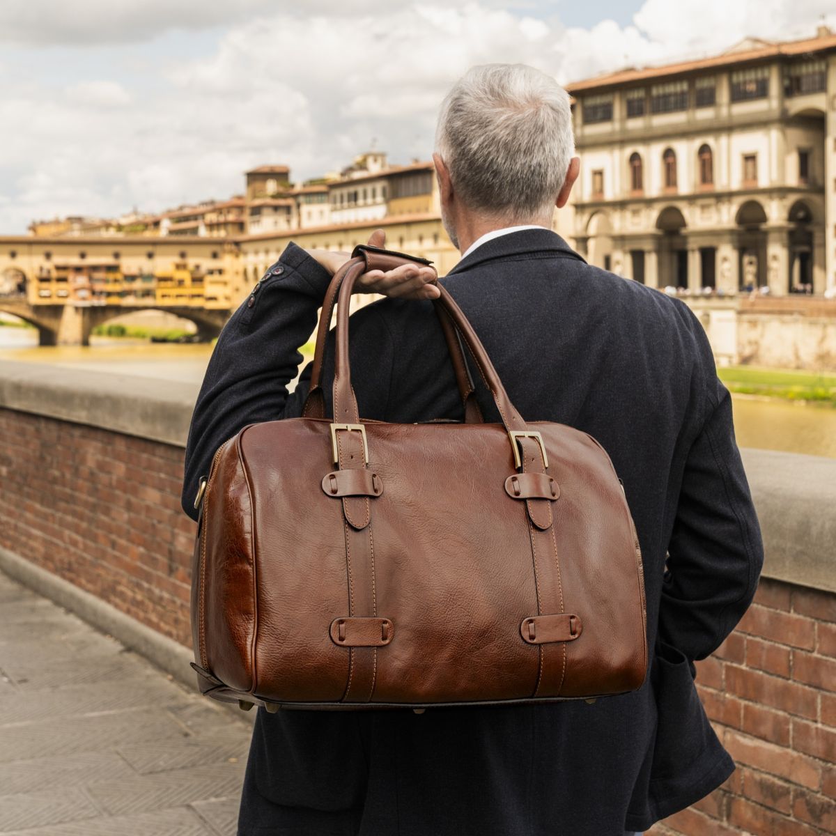 Donna con borsa da viaggio in pelle marrone in una strada cittadina