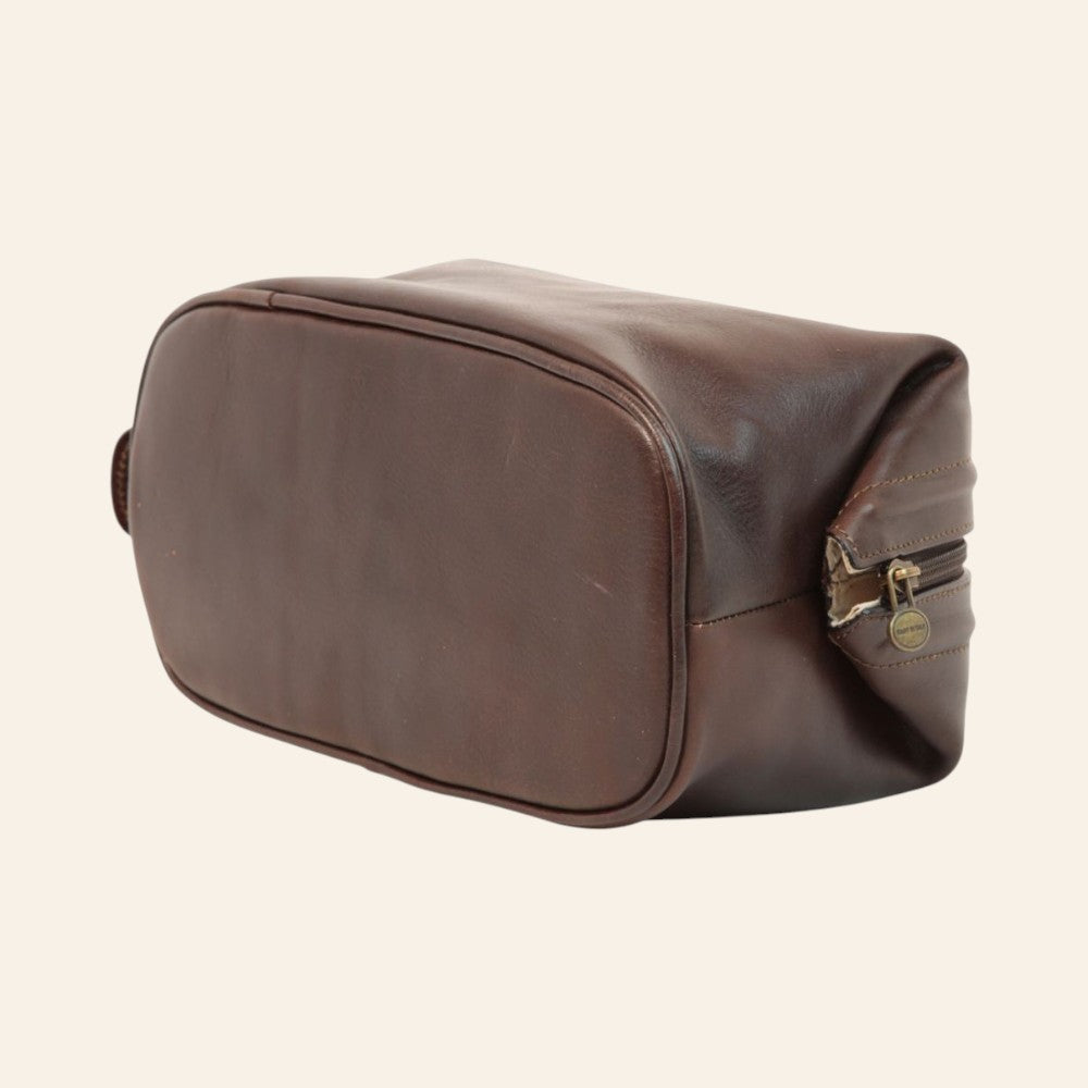 Unteransicht der Kulturtasche aus dunkelbraunem Kalbsleder mit Nähten und umlaufendem Reißverschluss