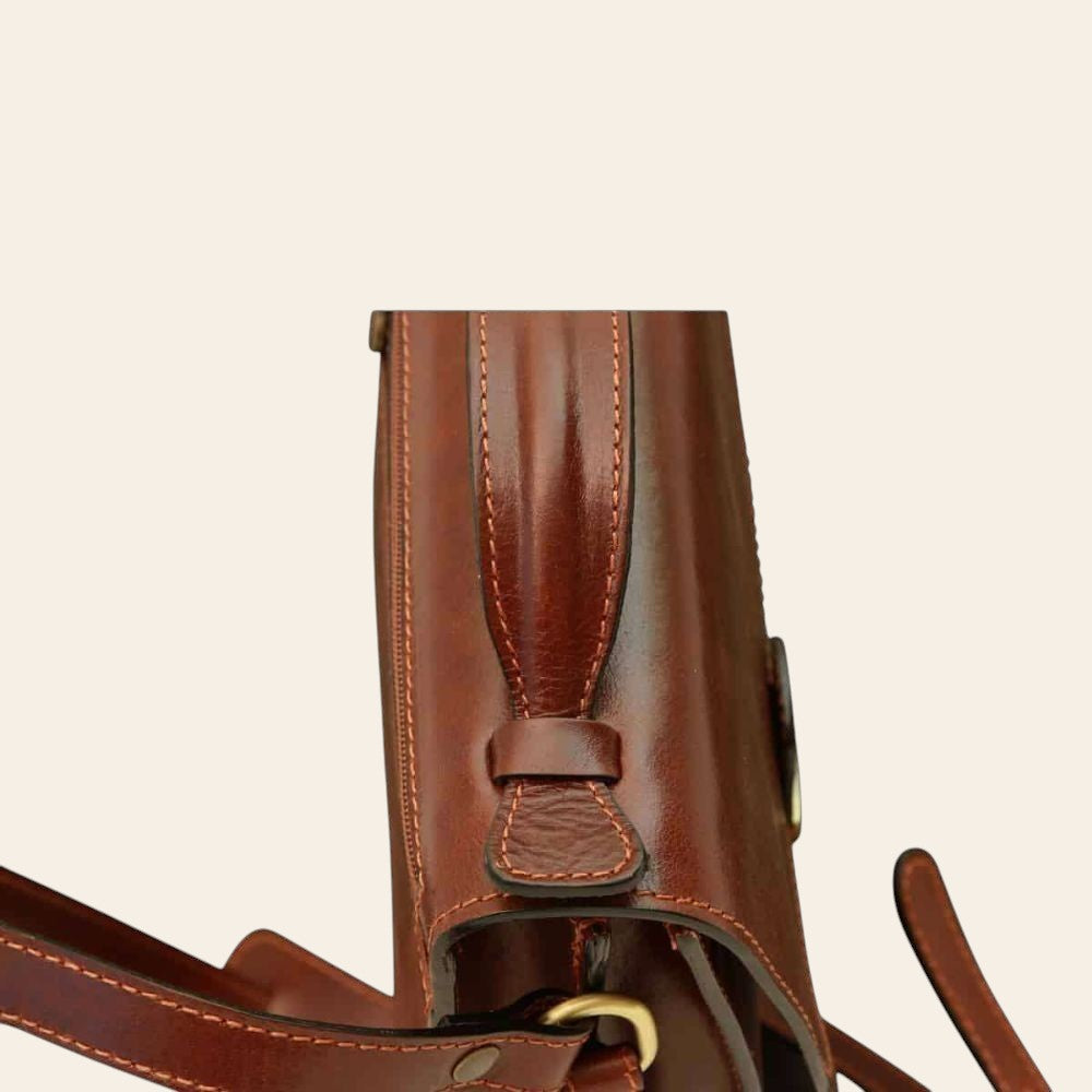 Borsa a tracolla in pelle marrone, dettaglio attacco tracolla con cuciture decorative.