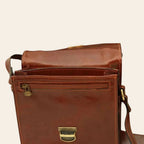 Borsa a tracolla in pelle marrone con zip frontale e chiusura a fibbia metallica.