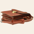 Borsa a tracolla in pelle marrone con patta superiore e chiusura frontale a fibbia.