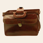 Borsa da medico in pelle marrone con maniglia imbottita e chiusura centrale dorata.