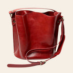 Secchiello in pelle rossa con tracolla in cuoio e fibbie metalliche dorate