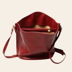 Borsa secchiello rossa in pelle con apertura superiore e dettagli metallici dorati