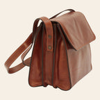 Borsa a tracolla in vitello pieno fiore marrone con patta e tasche laterali esterne.