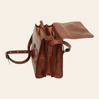 Borsa a tracolla marrone in vitello pieno fiore, tracolle regolabili e chiusura superiore.
