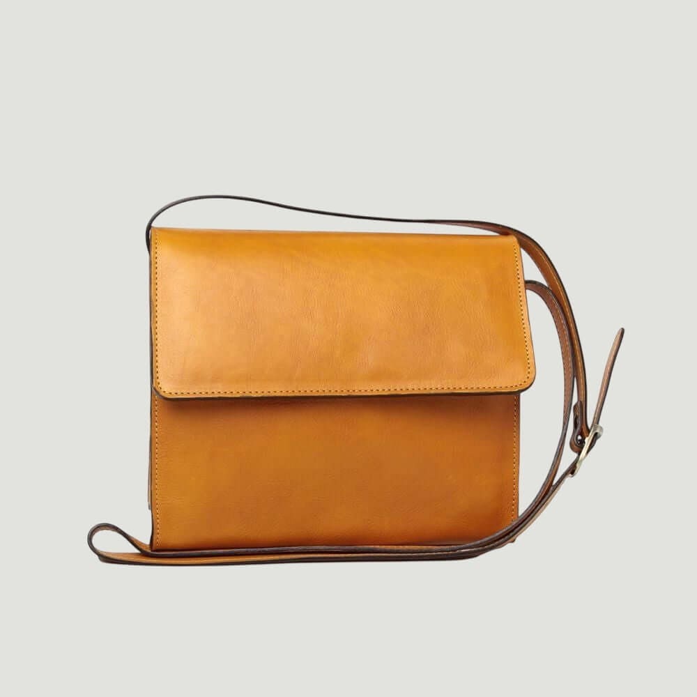 Borsa a tracolla ocra in vitello pieno fiore con patta e tracolla in cuoio.