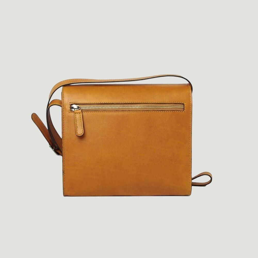 Borsa a tracolla ocra in vitello pieno fiore con patta e zip frontale.