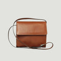 Borsa a tracolla in pelle teak, patta frontale e tracolla regolabile.