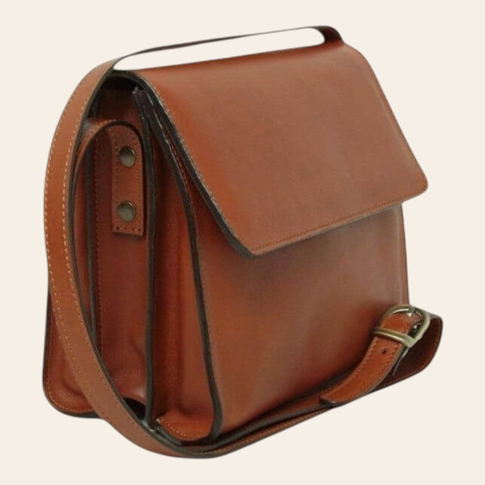 Borsa in pelle color teak con chiusura a patta e tracolla in cuoio, finiture metalliche.