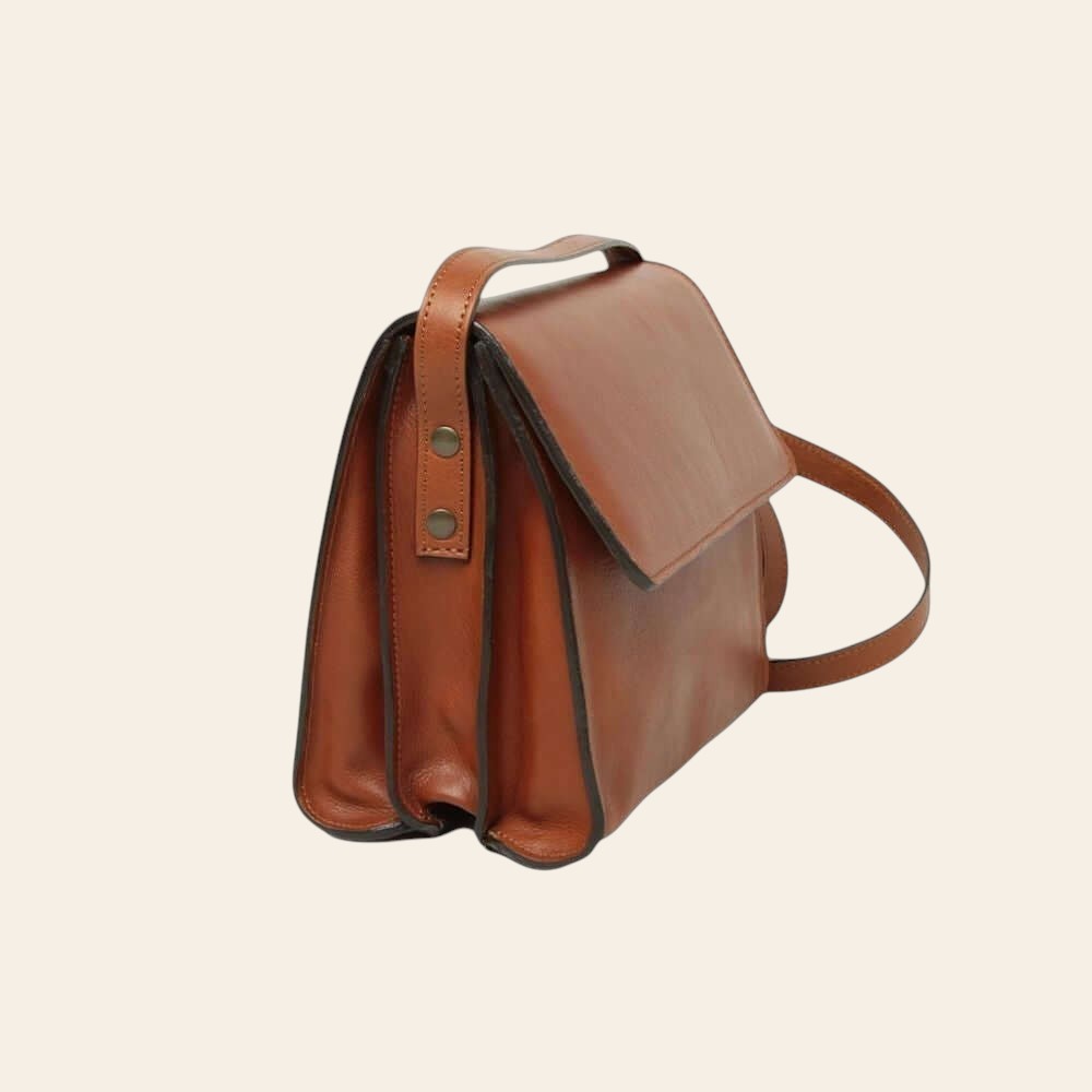 Borsa a tracolla in pelle teak, vista laterale con fibbie e tracolla.