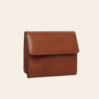 Borsa a tracolla in pelle color teak con pattina frontale e dettagli fibbie laterali.