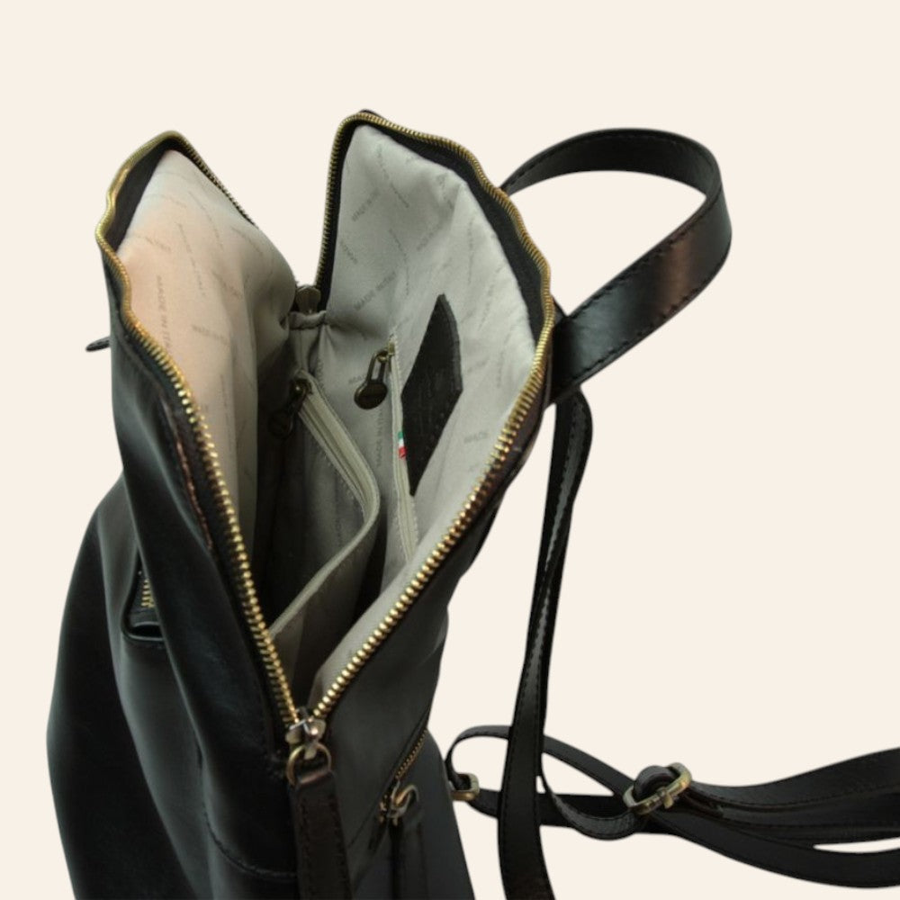 Zaino in pelle nera aperto: interno chiaro e tasche con zip
