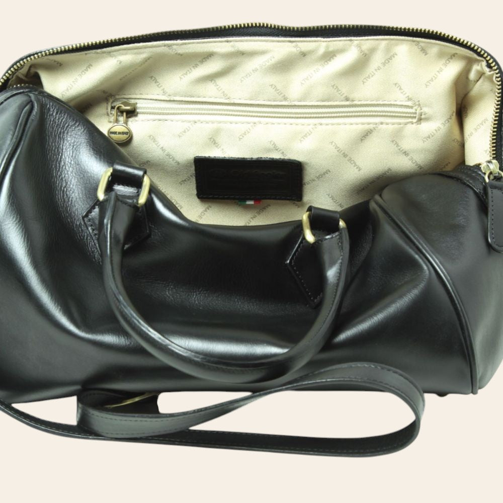 Interno del bauletto in pelle nera con fodera chiara, tasca e zip