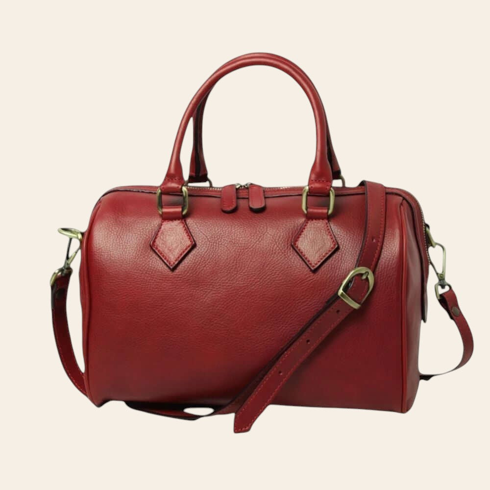 Bauletto in pelle rossa con due manici, tracolla e chiusura zip.