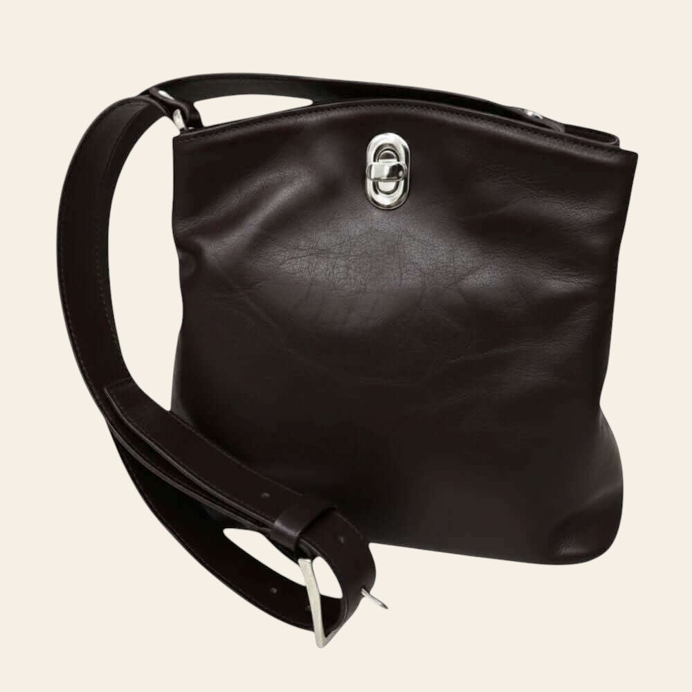 Borsa secchiello in pelle nera, dettaglio fibbia superiore e tracolla