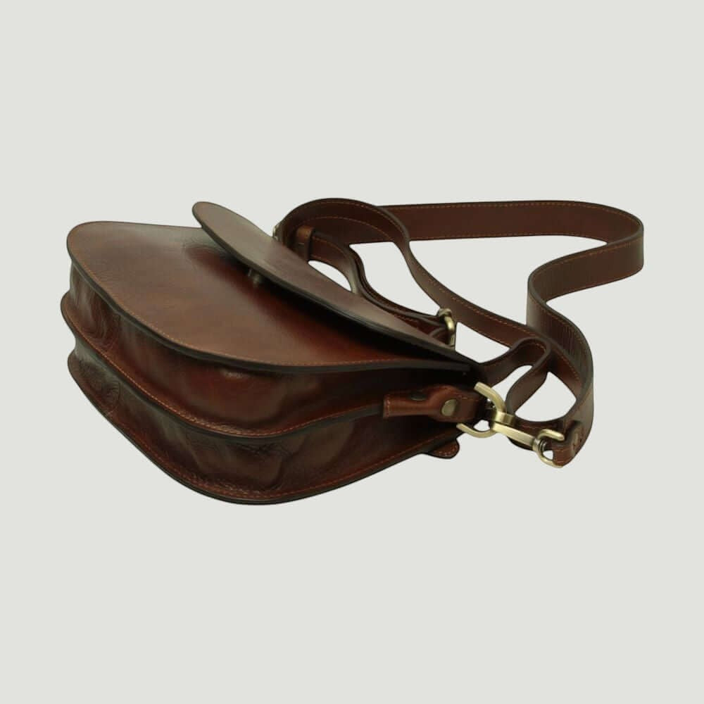 Borsa a tracolla marrone vista laterale con patta e supporto in metallo, profilo sagomato