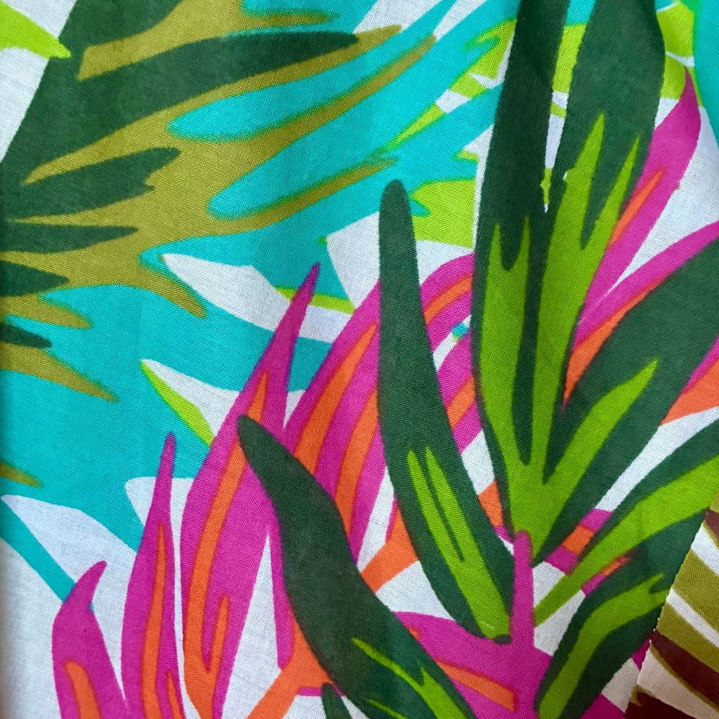 Dettaglio del tessuto del kimono da spiaggia in cotone con design floreale colorato.