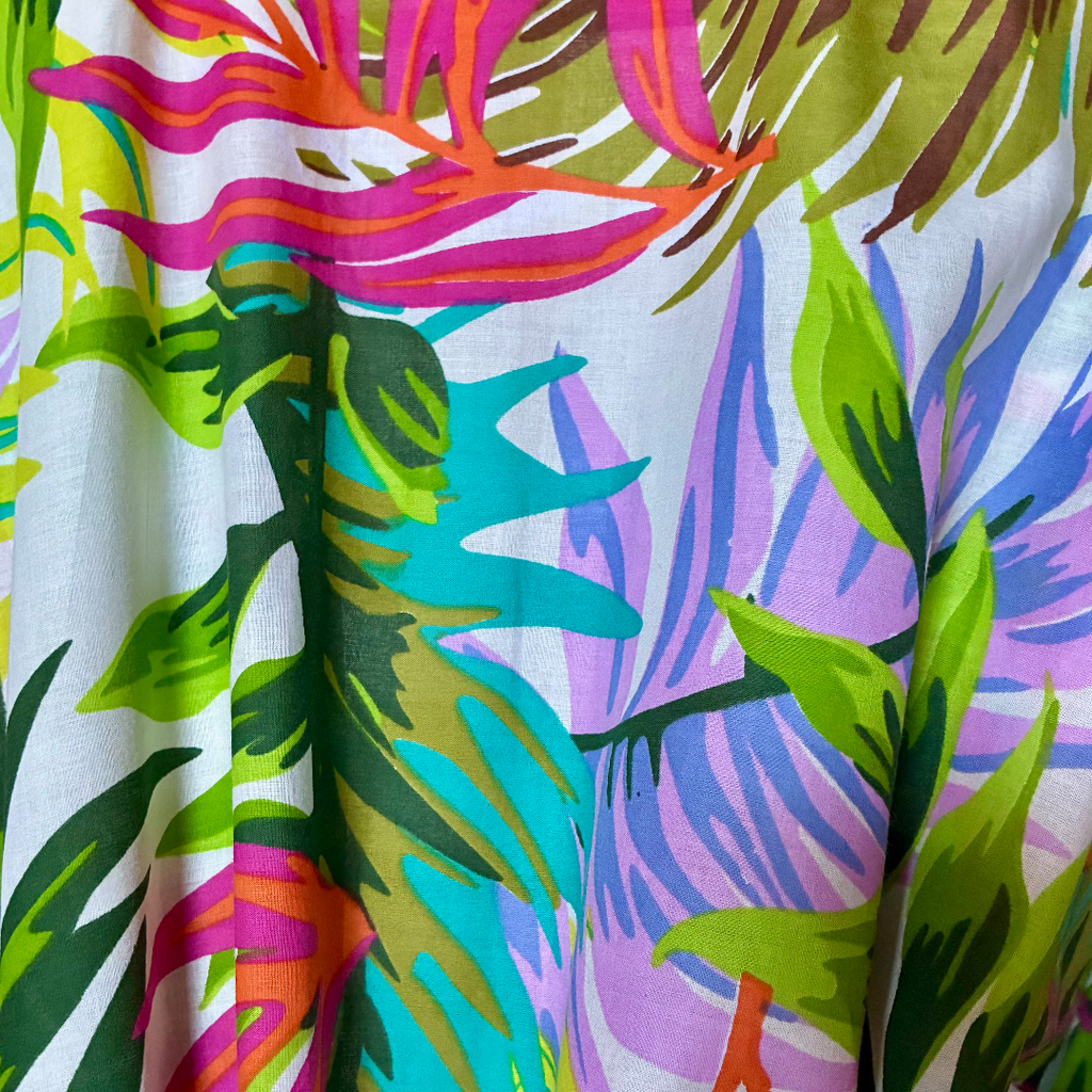 Tessuto colorato del kimono da spiaggia in cotone con motivi tropicali e foglie vivaci.