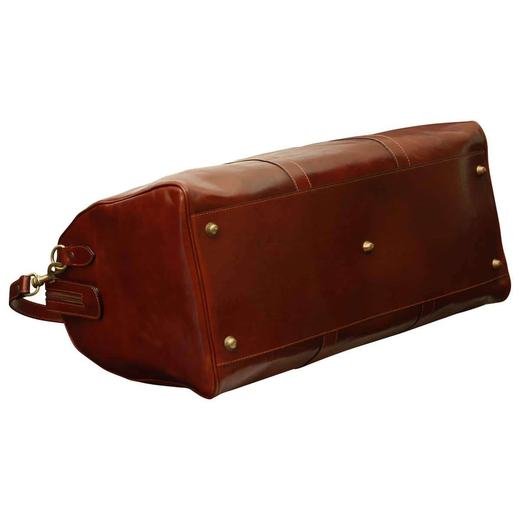 Borsa da viaggio pelle marrone vista dal basso con piedini in ferro e tracolla staccabile.