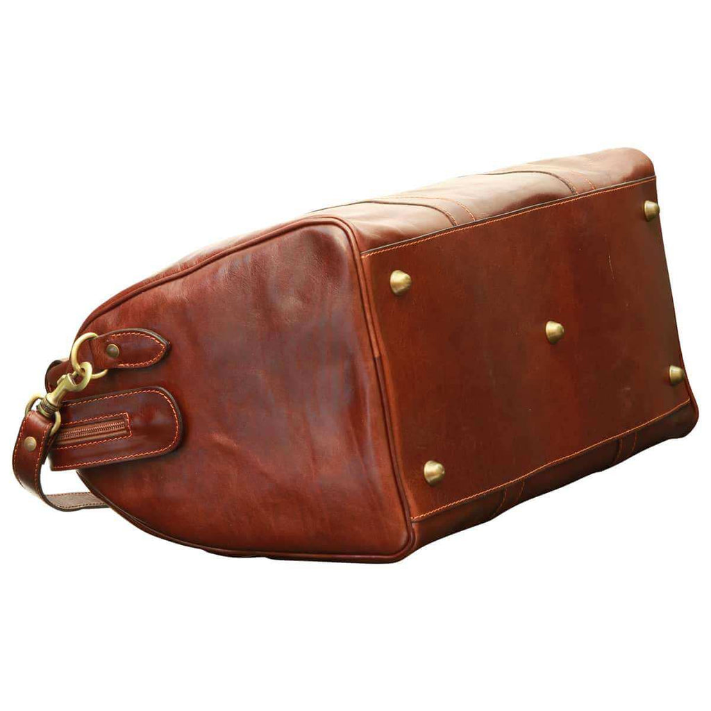 Borsa da viaggio uomo pelle marrone vista laterale con fondo protetto e tracolla in pelle.