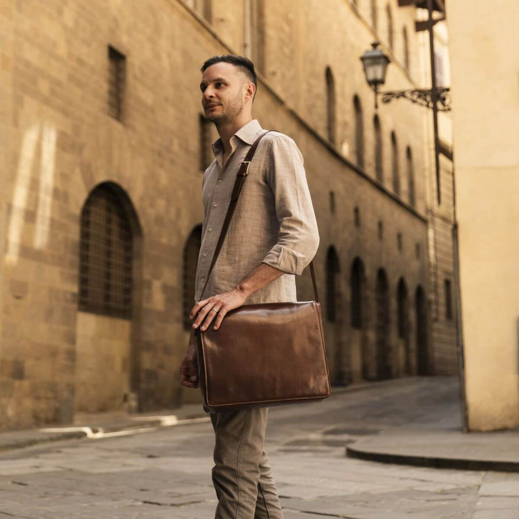 Borsa messenger in pelle scura con patta e tracolla, vista frontale