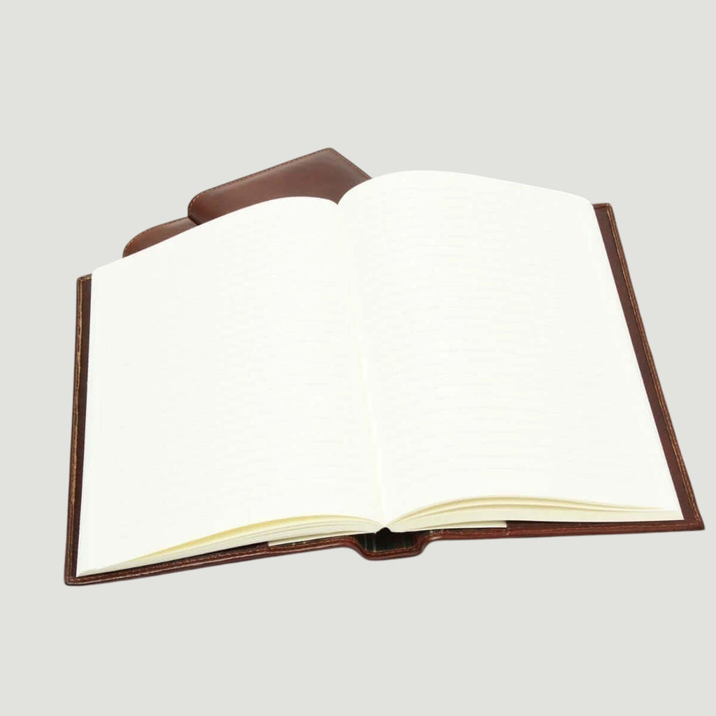 Diario in pelle marrone aperto con pagine bianche e copertina rigida