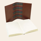 Diario in pelle marrone piccolo, aperto con pagine bianche e fodera a tartan.