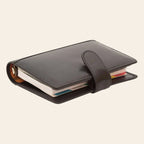 Organizer in pelle nero con chiusura a cinturino e pagine all’interno