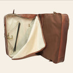 Porta-abiti in pelle marrone aperto, fodera chiara e tasche interne con zip.
