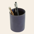 Portapenne in pelle blu scuro con penne inserite e cucitura chiara sul bordo