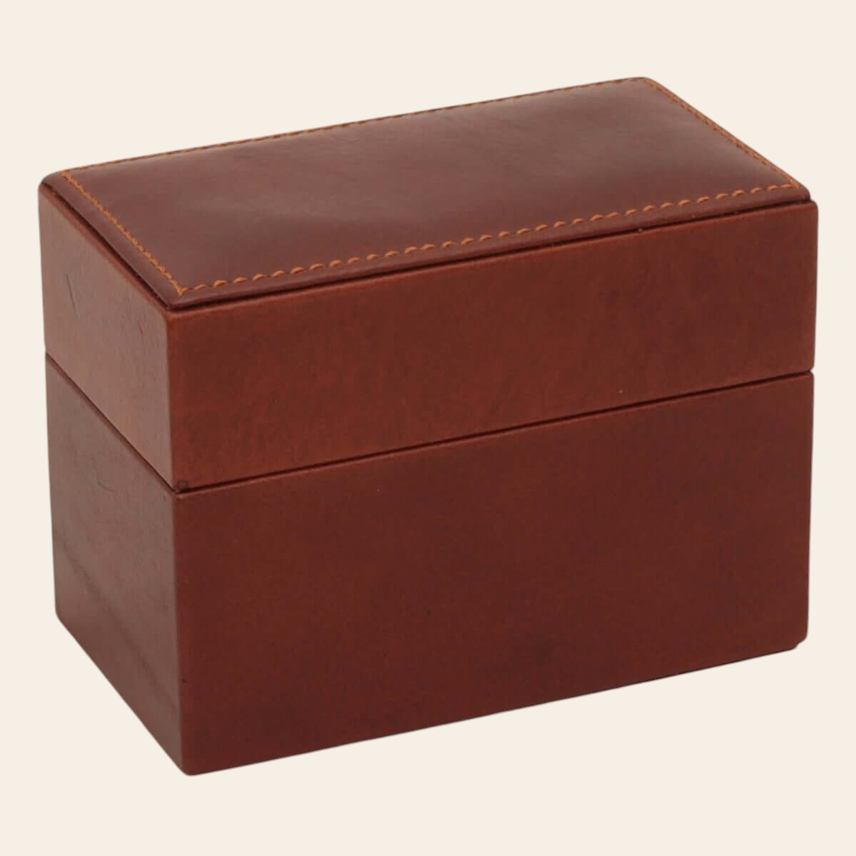 Scatola porta carte in pelle marrone chiusa con cuciture decorative sul coperchio.