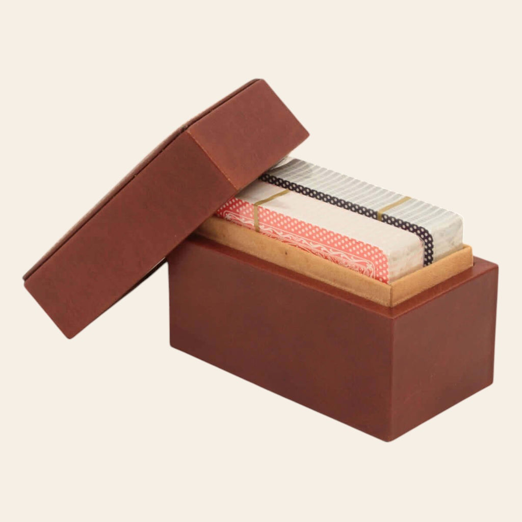 Scatola porta carte in pelle marrone con coperchio aperto e carte visibili nel vano.