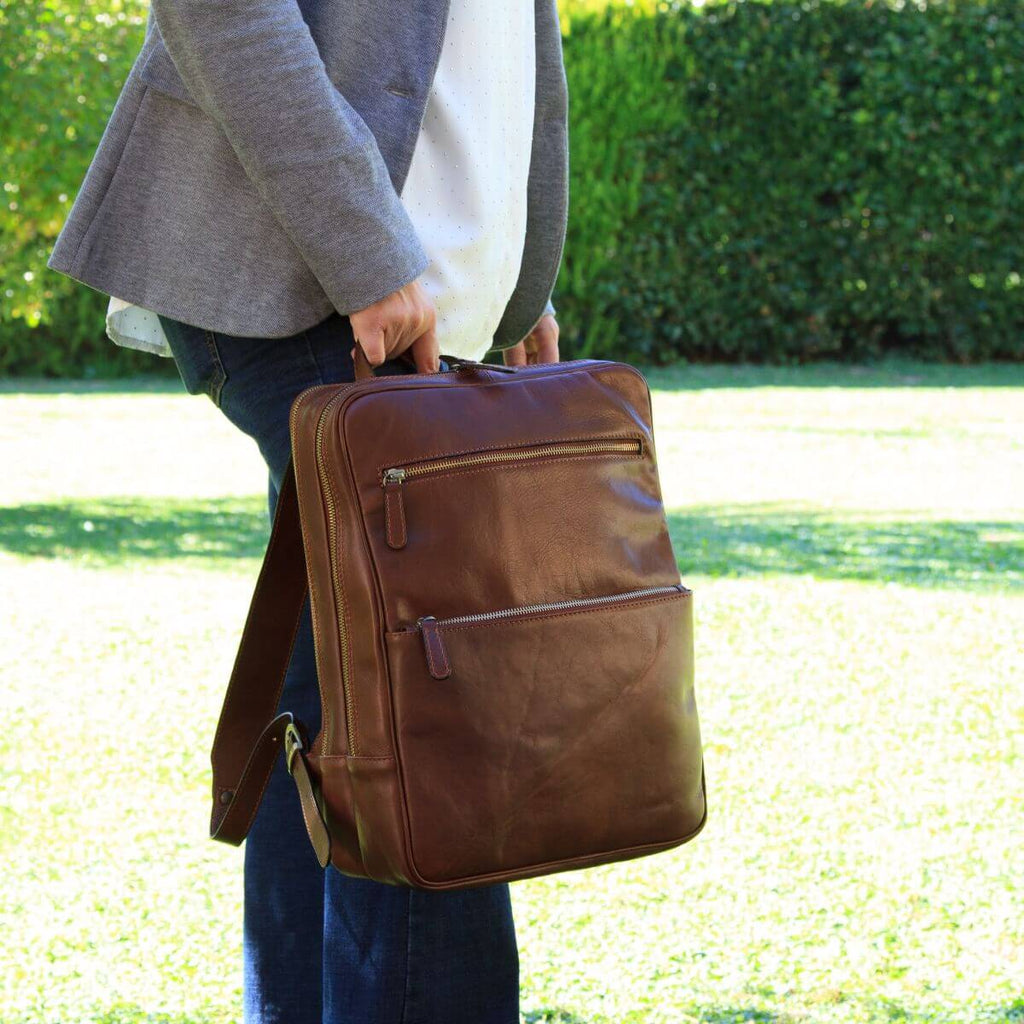 Brown full-grain calfskin backpack, with two front pockets and metal zips