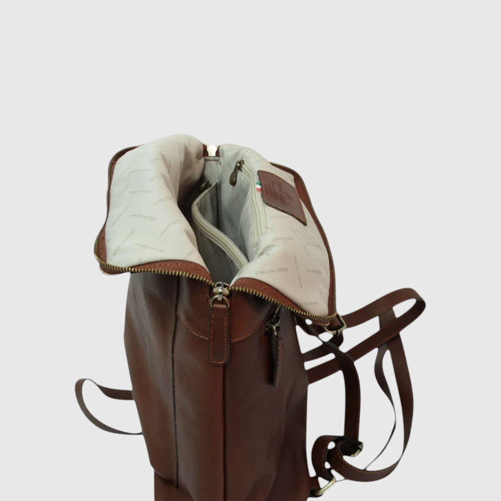 Zaino in pelle marrone aperto con fodera chiara e zip superiore