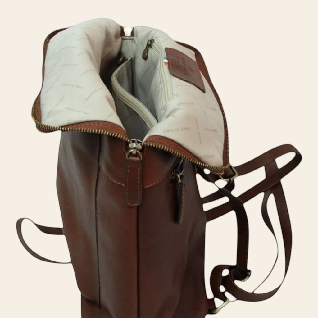 Zaino in pelle marrone aperto con foderina chiara e zip per chiusura