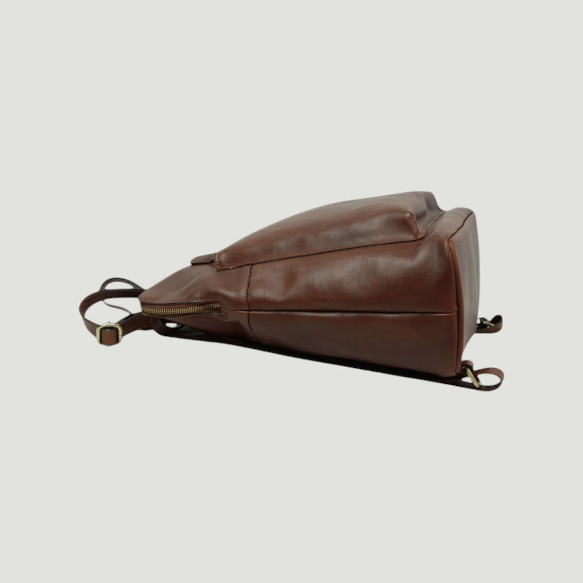 Zaino in pelle marrone di lato con zip e cinghie regolabili