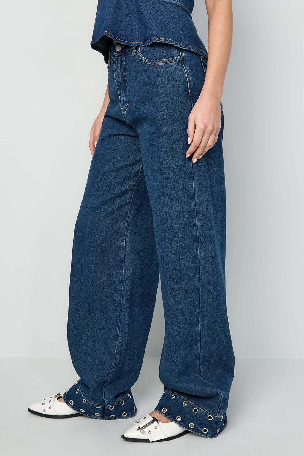 Jeans con occhielli