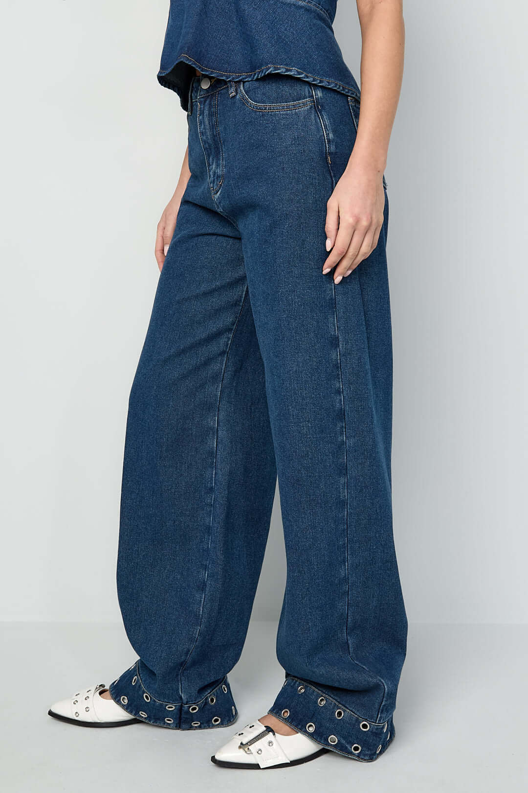 Jeans con occhielli