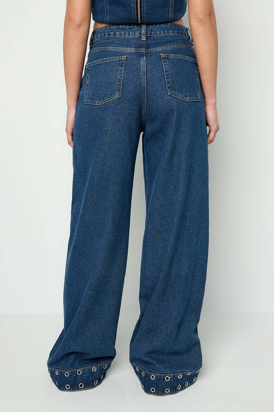 Jeans con occhielli