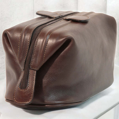 Beauty case in pelle marrone scuro con zip laterale e fascia per trasporto