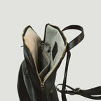 Interno di zaino in pelle nero con fodera chiara e tasche laterali con zip