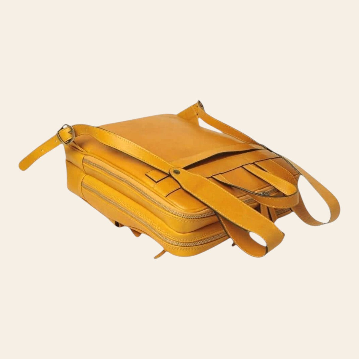 Zaino in pelle giallo ocra con scomparto interno visibile e tracolla laterale