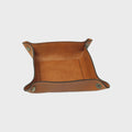 Vuotatasche in pelle color cuoio con bordi rivoltati e fori metallici