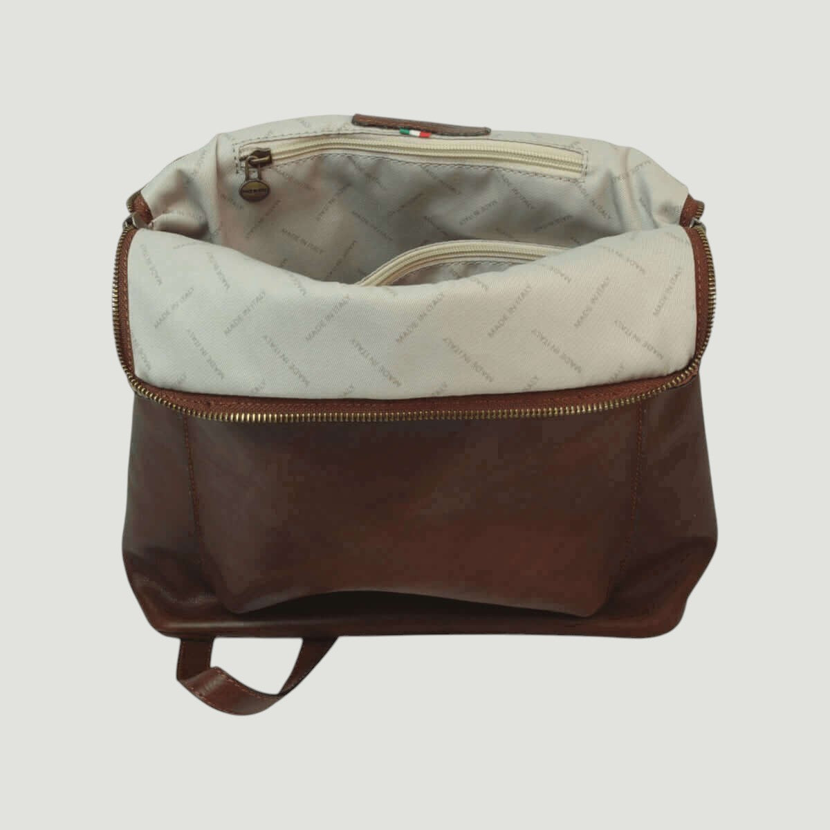 Zaino in pelle marrone con interno in fodera chiara e tasca superiore con zip
