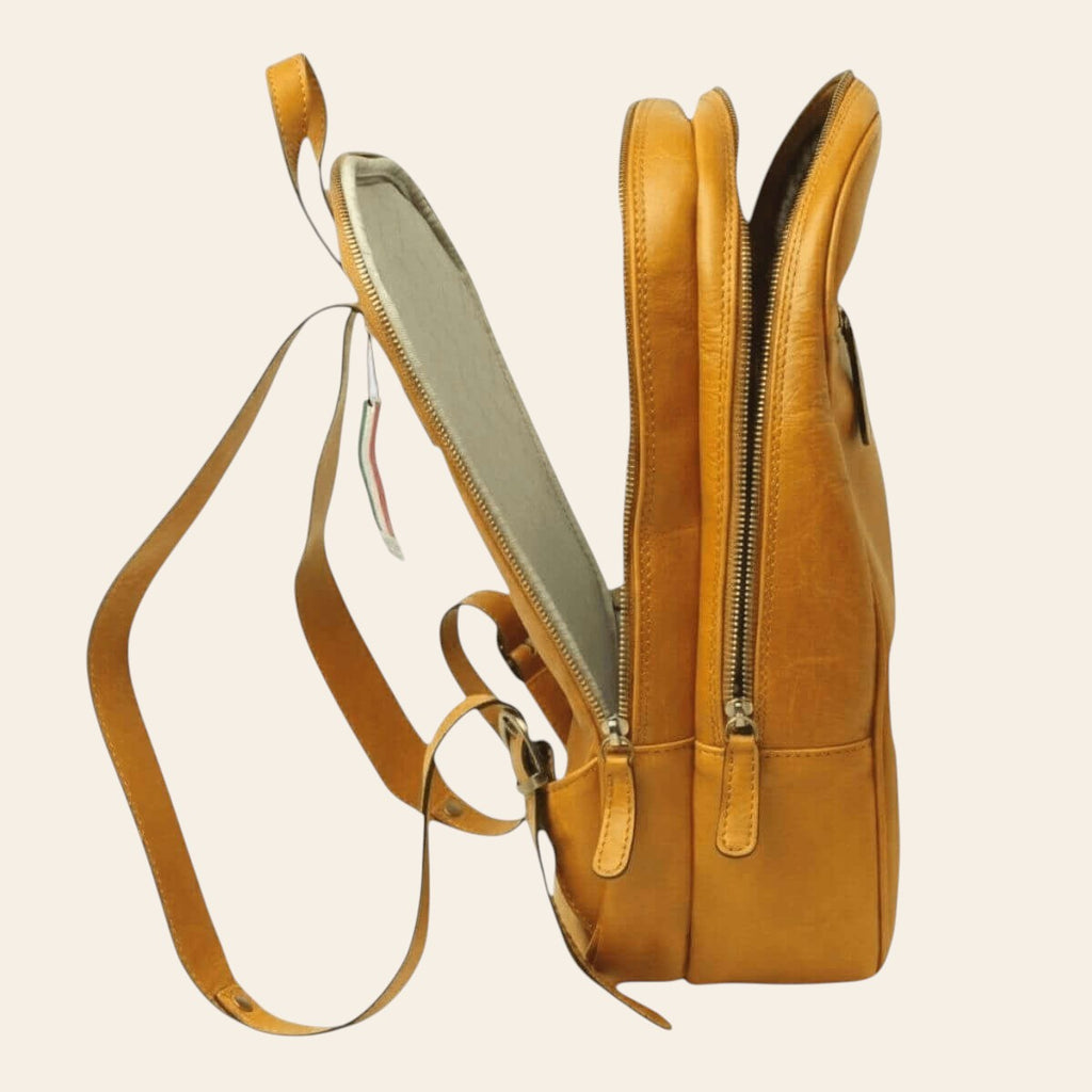 Vista lateral de una mochila de piel de becerro plena flor amarillo ocre con cremallera y tirante ajustable