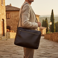 Borsa messenger in pelle nera con tracolla, manico e tasca frontale con zip.