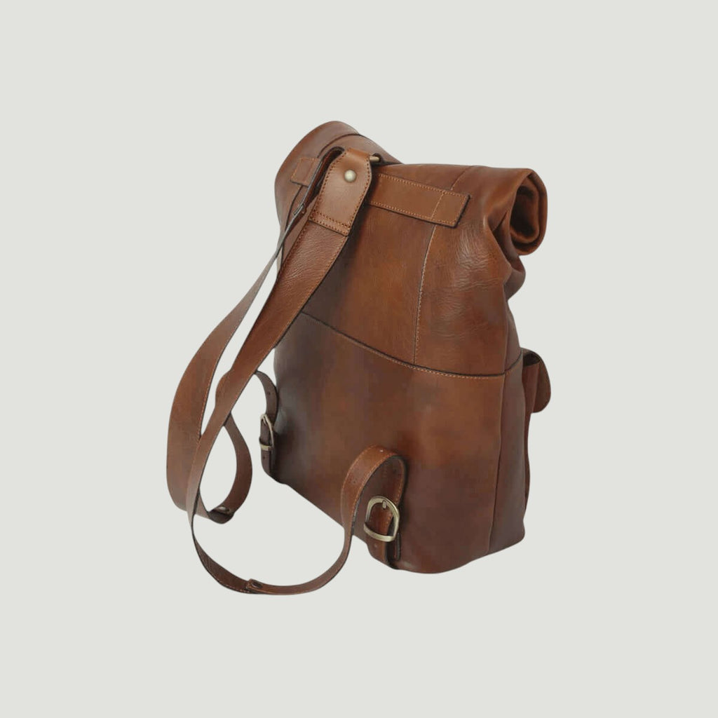 Zaino in pelle castagna con tracolla lunga e fibbie metalliche laterali.