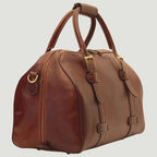 Borsone da viaggio in pelle marrone con doppie fibbie e tasche frontali.