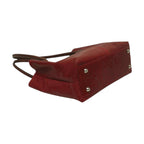 Borsa a spalla rossa bicolore con borchie metalliche sul fondo e angoli rinforzati